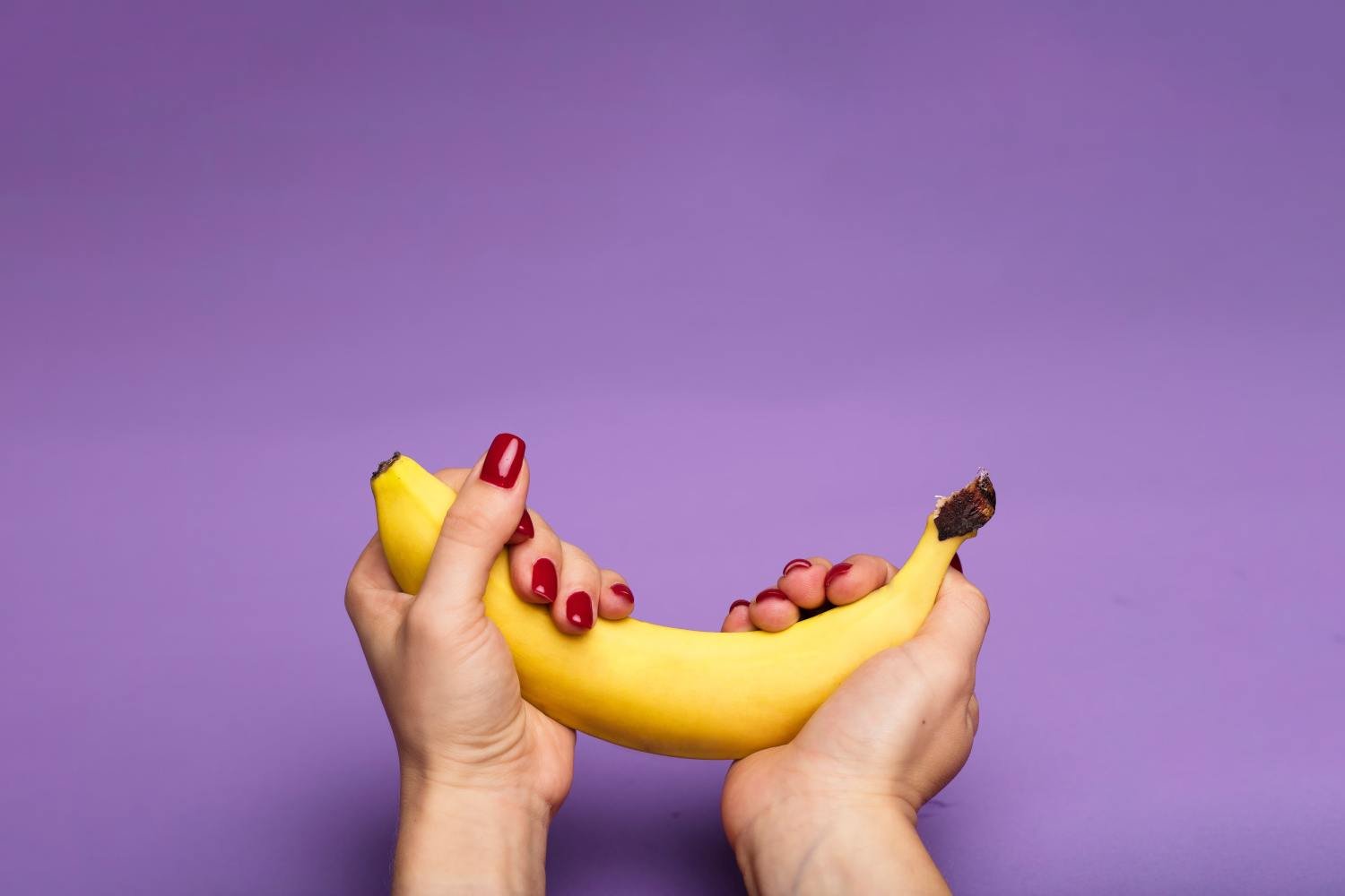 Kranus Edera: Frau die Banane in beiden Händen hält