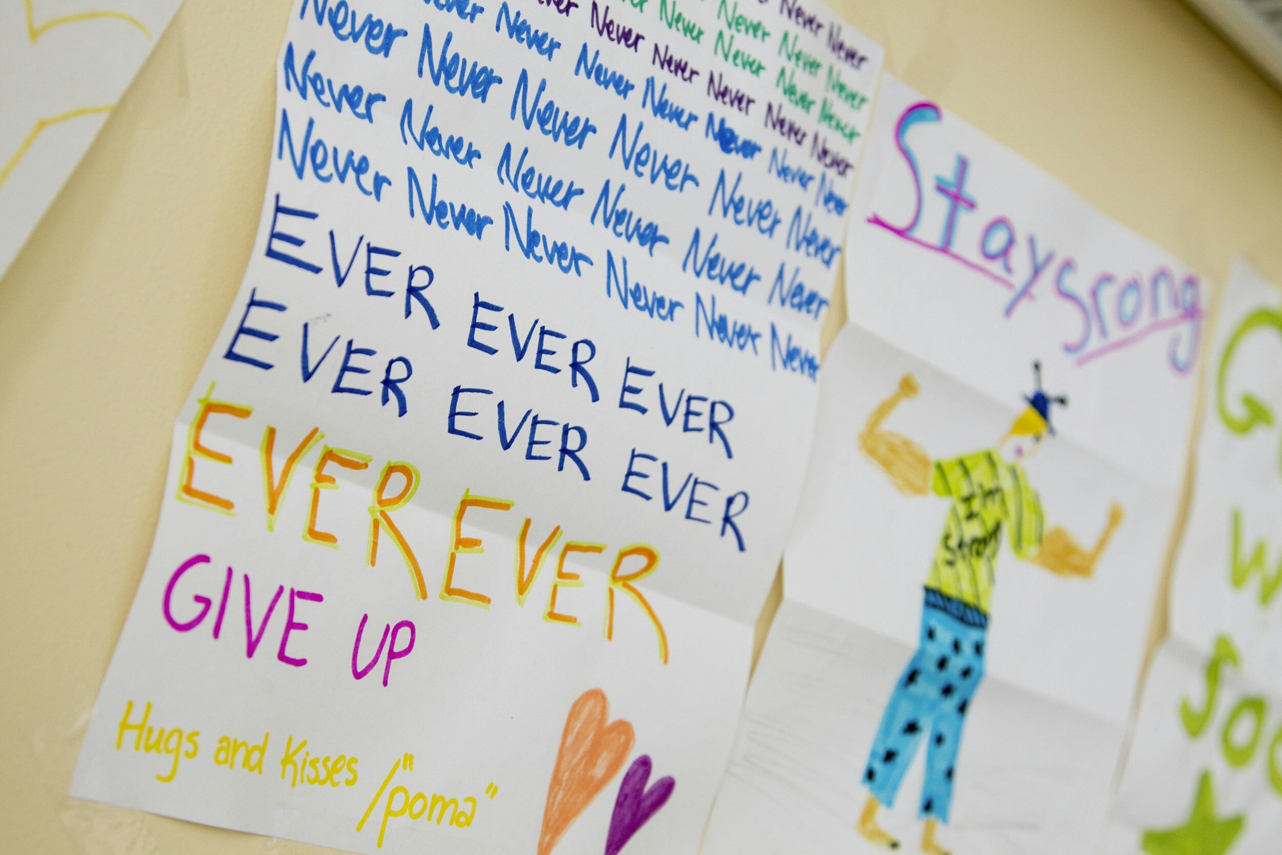 Kranus Health: Papier mit den Worten "stay strong" von Kinderhänden gemalt