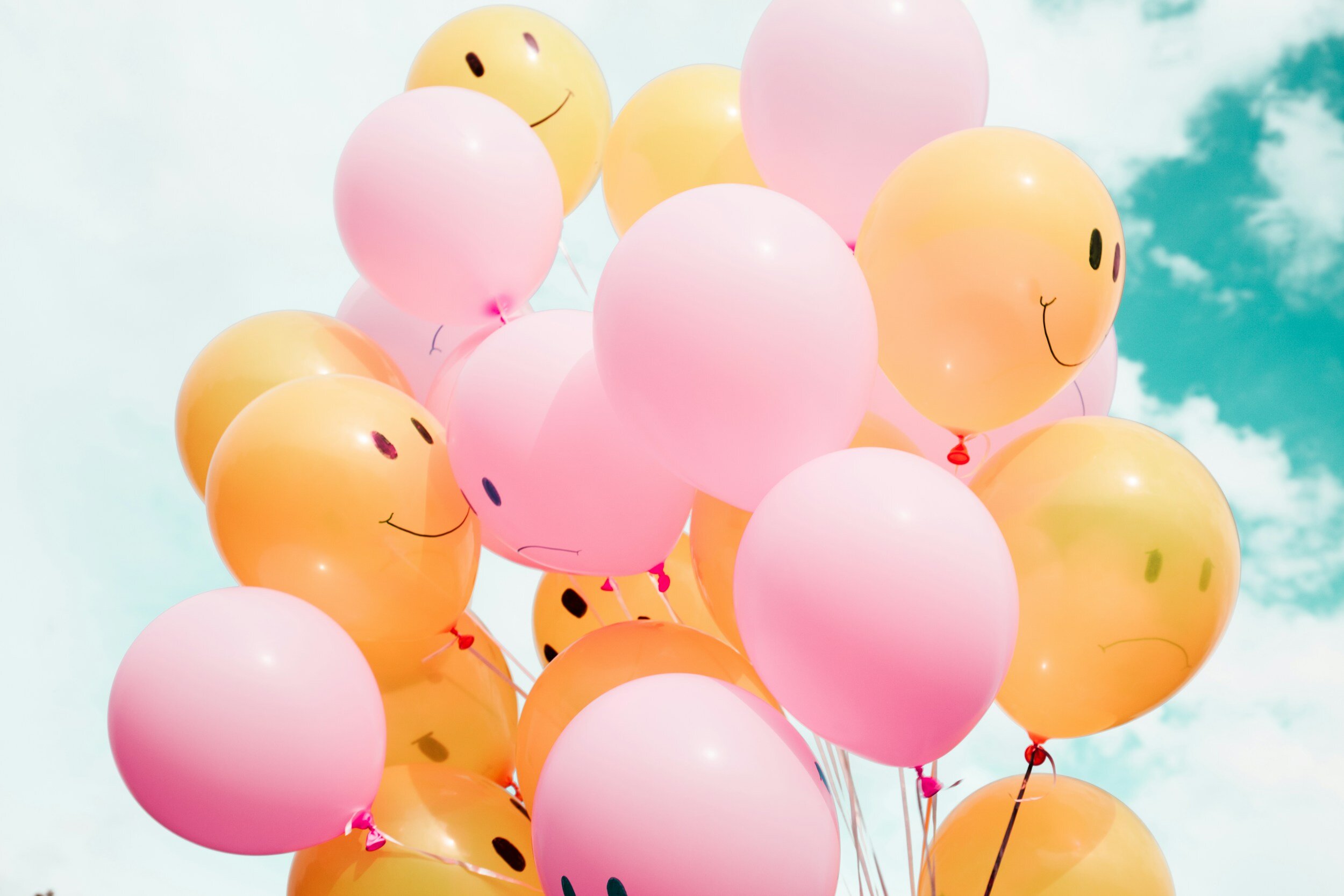 Kranus Health: Bunte Smiley Luftballons vor Himmel