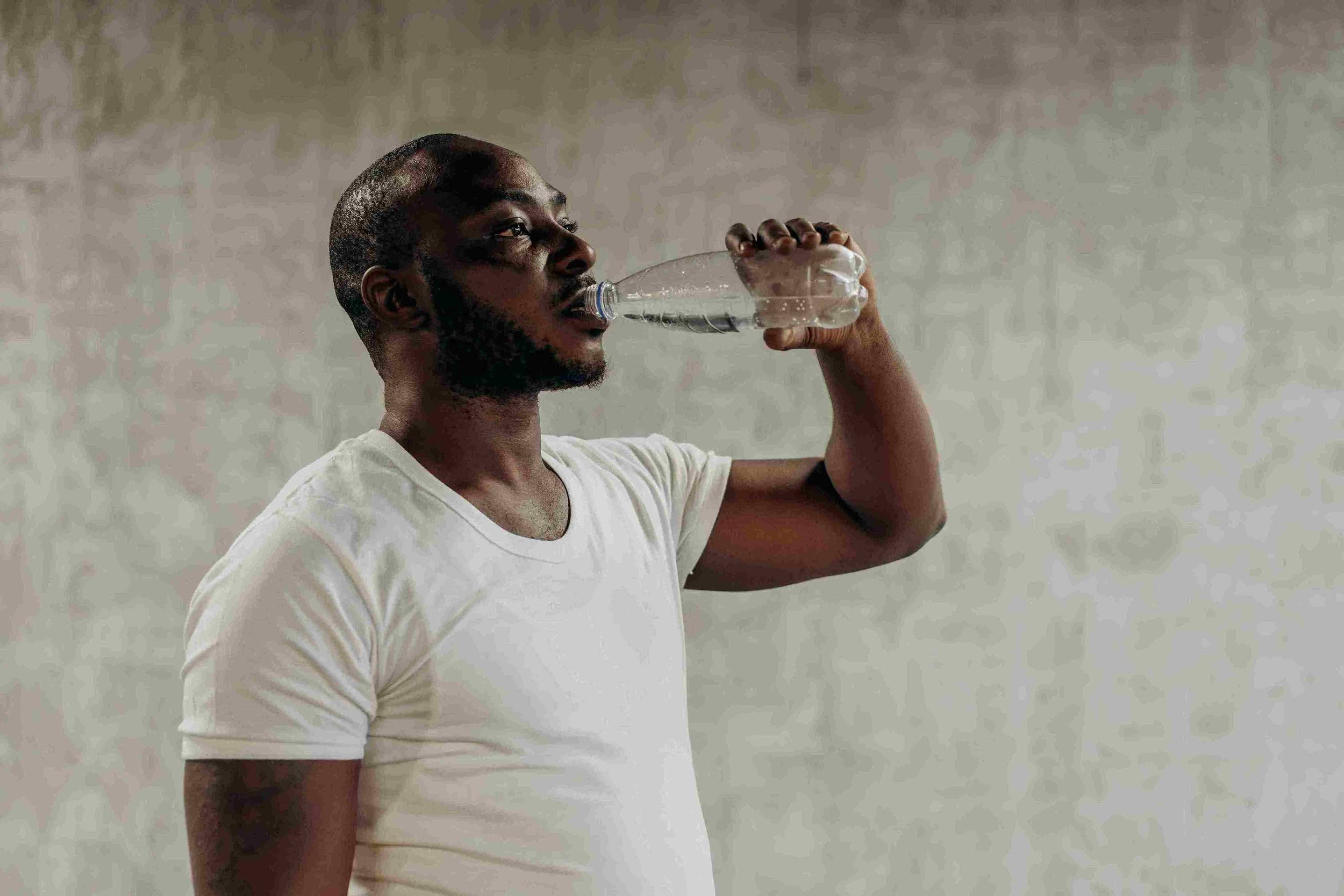 Kranus Edera: Mann der Wasser aus Flasche trinkt
